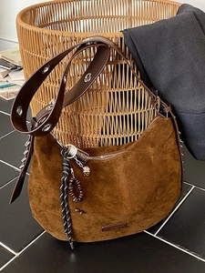 Sac demi-lune en daim marron avec bandoulière en cuir et grands œillets argentés