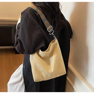 Détail du sac seau en toile avec bandoulière brodée de style ethnique bleu et orange
