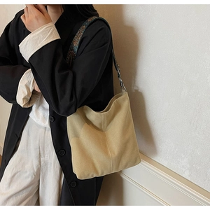 Détail du sac fourre-tout en daim kaki avec une large bandoulière brodée au style ethnique