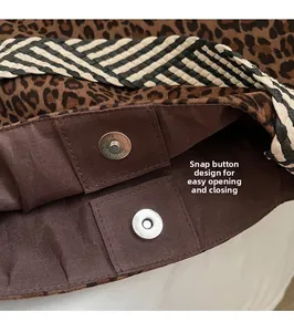 Vue détaillée du fermoir magnétique sur le sac fourre-tout léopard avec bandoulière tissée