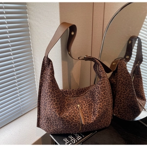 Détail du motif léopard en daim et de la large bandoulière marron réglable du sac