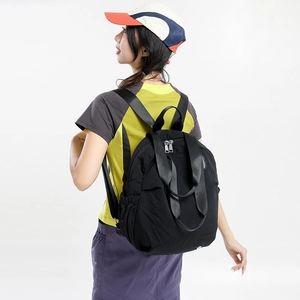Rear view of a model wearing a large capacity black nylon backpack with wide shoulder straps