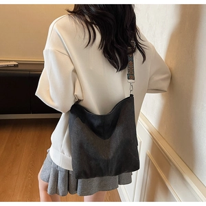 Détail du sac hobo en toile noire avec une large bandoulière jacquard de style ethnique