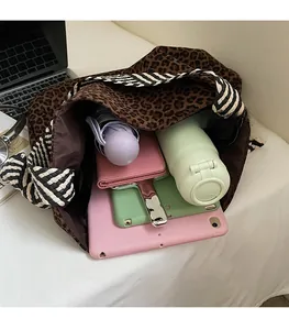 Intérieur spacieux du grand sac fourre-tout léopard contenant une tablette et objets