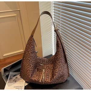 Gros plan du sac en toile léopard avec large bandoulière marron et fermeture éclair en métal