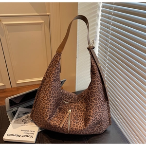 Détail du sac cabas en daim léopard avec bandoulière en cuir marron et boucle dorée