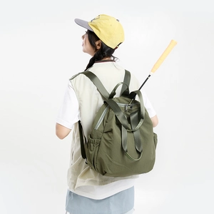 Dark green nylon multi-functional backpack showing a badminton racket stored inside