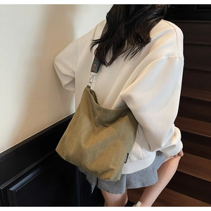 Detail of olive canvas hobo bag featuring ethnic jacquard wide strap and silver metal hooks