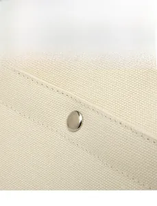Detailed close-up of metal magnetic buckle and woven canvas texture on large tote bag