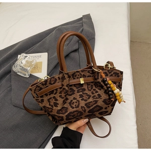 Detailed view of leopard print bucket bag with leather handles and wooden beads