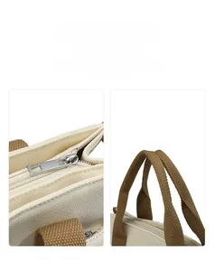 Detail of silver metal zipper and brown woven handle on a canvas tote bag