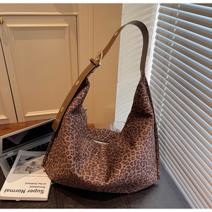 Détail du sac hobo léopard avec bandoulière réglable en cuir sur un bureau chic
