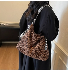 Détail du grand sac hobo léopard avec bandoulière rayée contrastée porté par un mannequin