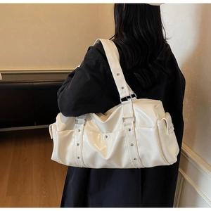 Detail view of cream white travel tote bag with silver rivets and glossy PU leather texture