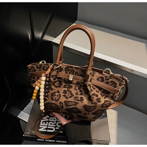 Detail der Leoparden-Eimertasche mit Perlen-Quastenanhänger und verstellbarem Gurt