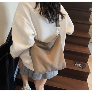Gros plan d'un grand sac bandoulière en toile avec sangle ethnique sur un escalier