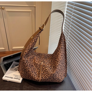 Détail du sac hobo à motif léopard avec bandoulière en cuir marron et fermeture éclair