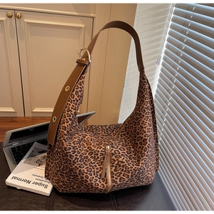 Détail du sac hobo léopard avec bandoulière en cuir brun et poche zippée latérale