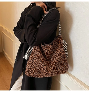 Détail du sac cabas léopard avec accessoire foulard rayé porté à l'épaule pour femme