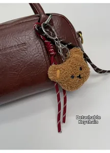 Macro di un ciondolo a forma di orso di peluche marrone rimovibile su una borsa in pelle
