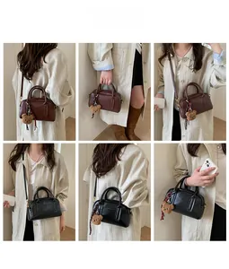 Dettagli di una borsa a mano vintage stile Boston con ciondolo a orsetto e tracolla