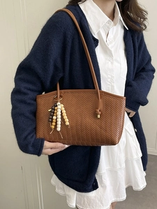 Brown woven tote bag with tricolor wooden bead tassel and long leather shoulder straps