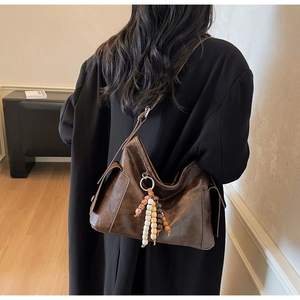 Close-up of deep brown vintage PU leather tote with multi-color beaded tassel accessory
