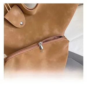 Detailed macro view of the silver metal zipper and soft brown leather on a tote bag