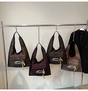 Detailed close-up of leopard print hobo bag with Noronoro text and yellow knot detail