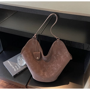 Detail der braunen Wildleder-Tragetasche mit V-Design und hängender kleiner Münztasche