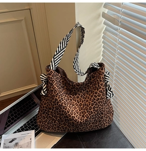 Détail du grand sac cabas hobo léopard avec ruban rayé décoratif sur la bandoulière