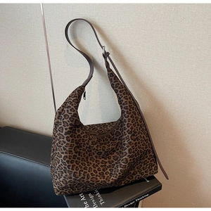 Détail du sac à bandoulière en daim léopard avec une fine lanière en cuir ajustable
