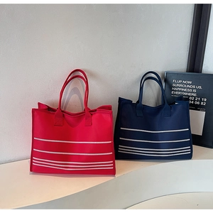 Canvas tote bags in red and blue featuring stylish white horizontal stripes on a stand