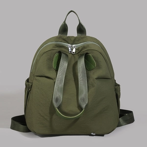 Detailed view of dark olive green nylon backpack with top handle and side drawstring pockets