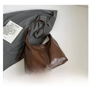 Detail view of large brown crossbody tote with premium oily leather texture and stitching