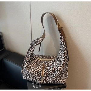 Détail du sac bandoulière léopard avec bandoulière en cuir et fermeture éclair dorée