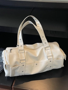 Cream white PU leather large travel tote bag with silver studs on a black display stand