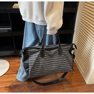 Detailed shot of striped travel bag with shoe compartment and adjustable nylon shoulder strap