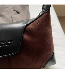 Detail view of stitched black leather and brown suede material with EST. 1999 engraving