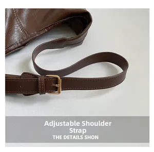 Detail of adjustable strap on brown faux leather tote with gold metal buckle