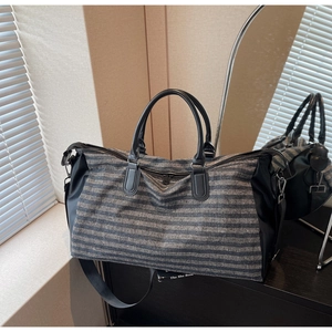 Detail of grey striped sports gym bag with shoe compartment and adjustable shoulder strap