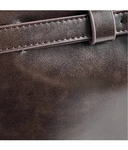 Détail de la texture cuir grainé marron foncé et de la boucle de la bandoulière