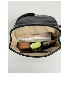 Detail view of the spacious inner compartment with zipper pocket in black leather bag