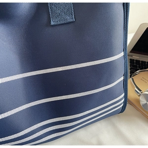 Detail of high-density navy twill fabric with parallel white stripes on a tote bag
