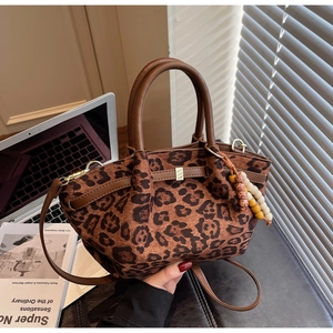 Detailansicht der Leopardenmuster-Textur mit Holzperlenanhänger und Ledergriff am Bag