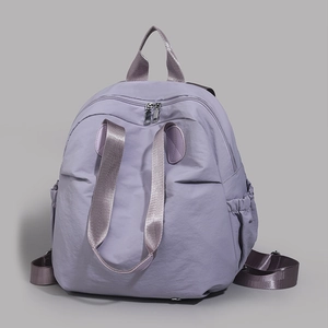 Detail view of purple nylon backpack with metal zippers and elastic side pockets