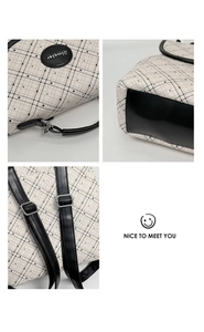Detail view of plaid backpack featuring adjustable black straps and metallic buckles