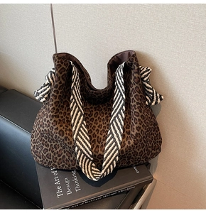 Détail du grand sac cabas léopard avec anses tissées et nœuds décoratifs latéraux