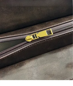 Détail de cuir marron foncé et fermeture éclair dorée brillante sur un sac à main