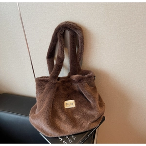 Gros plan du sac fourre-tout en peluche marron foncé avec étiquette de marque blanche